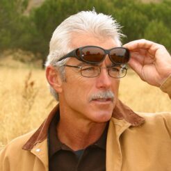 Man wearing fitovers sunglasses over prescription glasses outdoors, demonstrating comfort and eye protection for all ages.