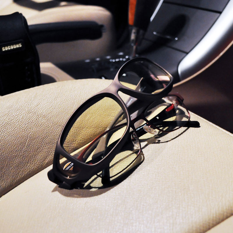 Cocoons night driving glasses sitting on a car seat with prescription glasses