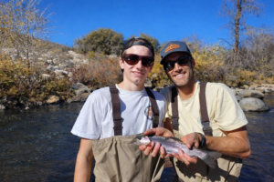 Outdoor fishing scene with two men wearing fitovers sunglasses, highlighting Fitovers for Every Generation in bright sunlight.